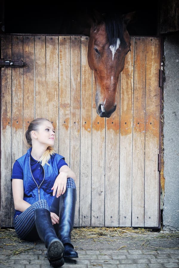 Equestrian girl and her horse in stable. Equestrian girl and her horse in stable