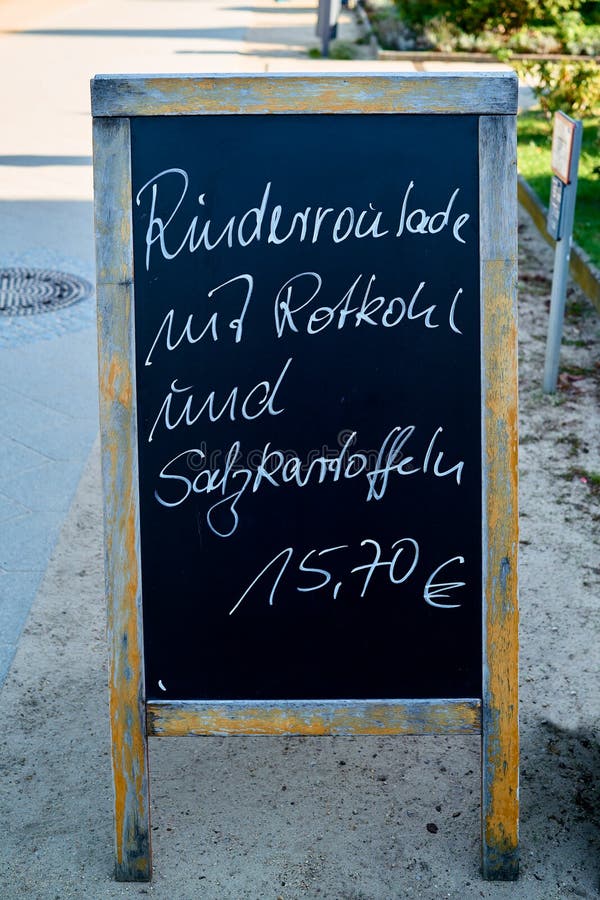 Rulada de vită cu varză roșie și cartofi. în fața unui restaurant, cu o ofertă de vânzare a cărnii de vită cu varză roșie și cartofi