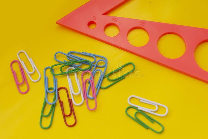Ruler and Multicolored Paper Clips on a Yellow Background. School