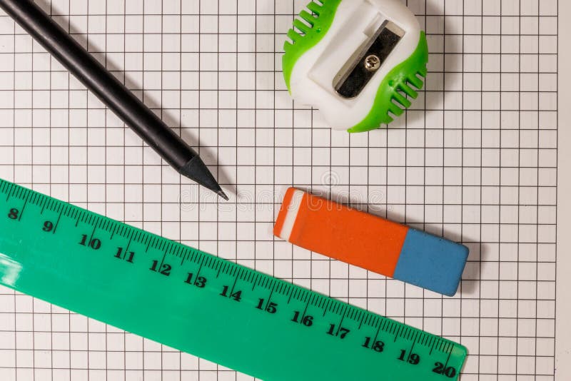 Ruler, Pencil, Sharpener and Eraser on Notepad Sheet Stock Photo