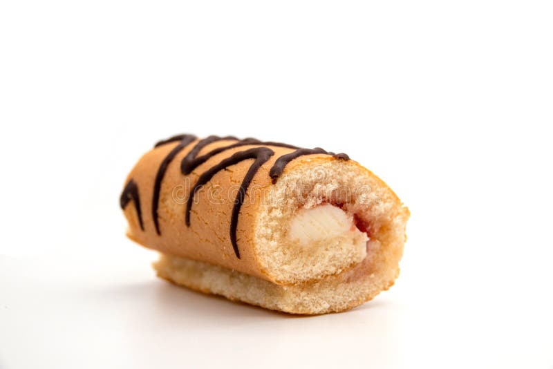 Rullande kaka, som är isolerad på vit bakgrund, svullen med vanilj kräm, skuren och skär med mjölkfyllning royaltyfria foton Rullande kaka, som är isolerad på vit bakgrund, svullen med vanilj kräm, skuren och skär med mjölkfyllning royaltyfria foton