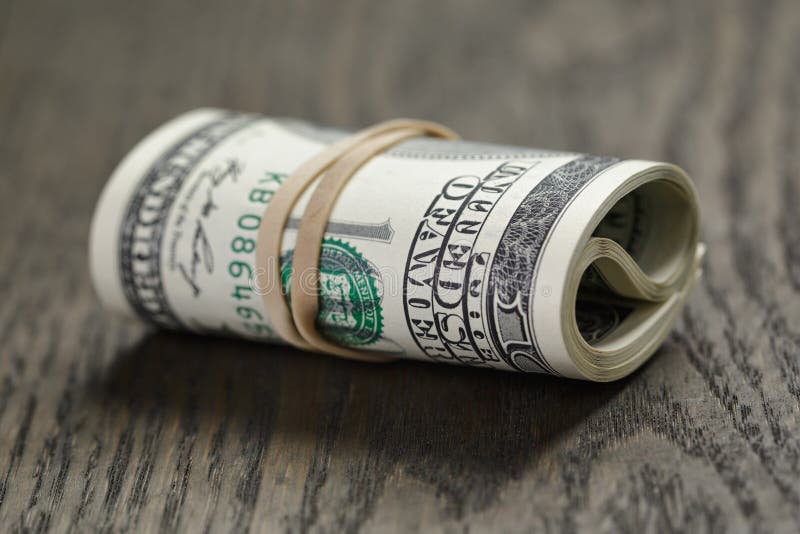 Rulle av ny stil hundra dollarräkningar på tabellen royaltyfri fotografi Rulle av ny stil hundra dollarräkningar på tabellen royaltyfri fotografi