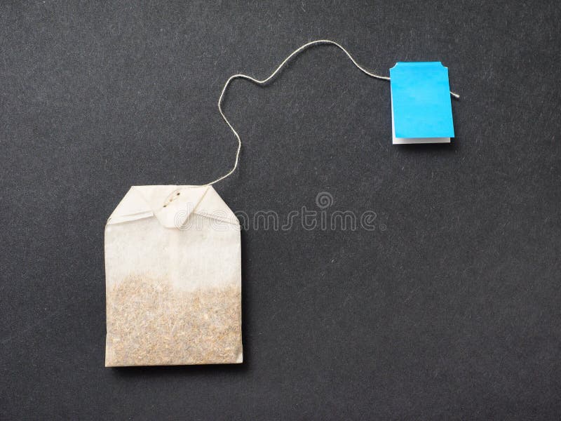 Camomile teabag on an elegant black background - lots of copy space. Camomile teabag on an elegant black background - lots of copy space