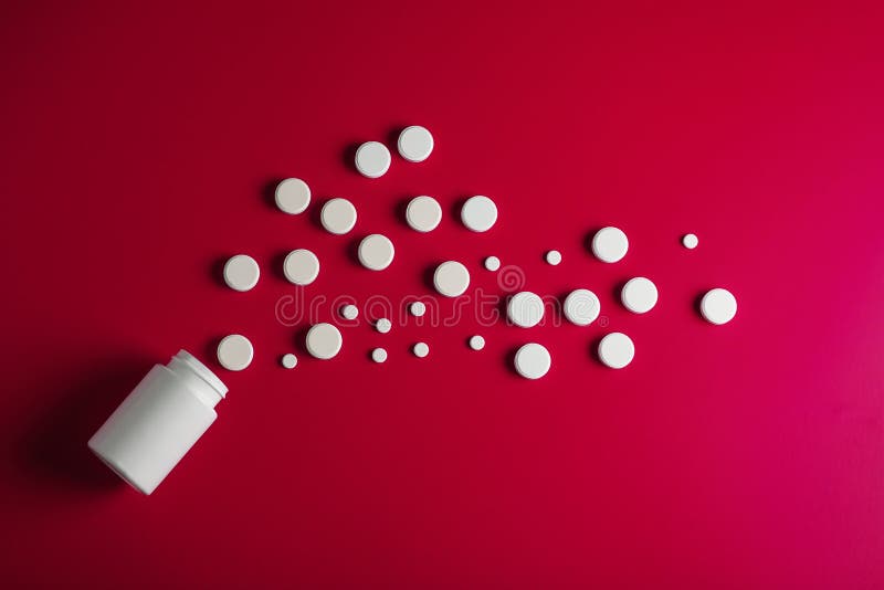 Rund form för medicinska preventivpillerar och röd bakgrund för ljus flaska arkivbild Rund form för medicinska preventivpillerar och röd bakgrund för ljus flaska arkivbild