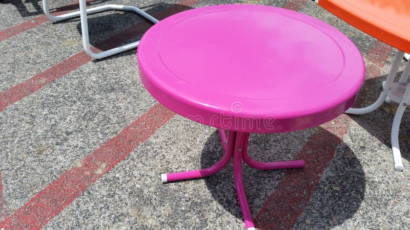 Runde rosa Himbeermetalltabelle auf Beton stockbilder