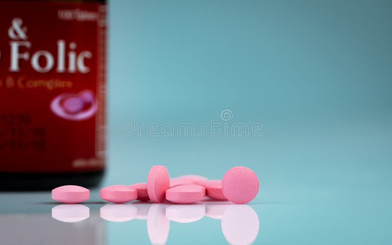 Runde rosa Tablettenpille auf Steigungshintergrund Vitamine und Mineralien plus Fols? urevitamin E und Zink in der Drogenflasche lizenzfreie stockfotografie
