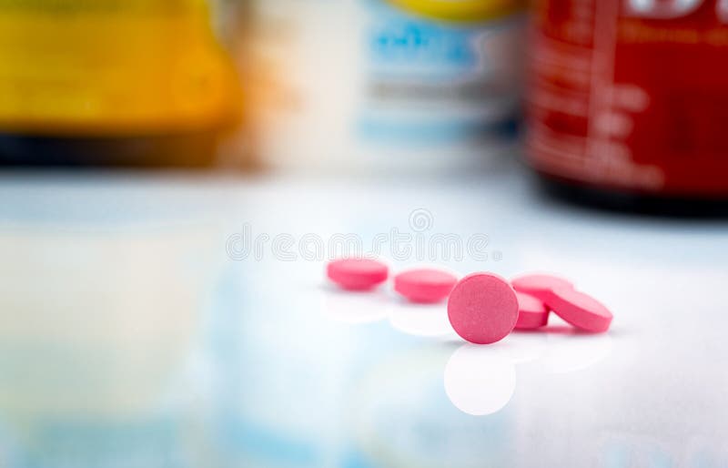 Runde rosa Tablettenpille auf unscharfem Hintergrund der Drogenflasche r Drogenkonsum für Behandlungsmigränekopfschmerzen lizenzfreie stockfotos