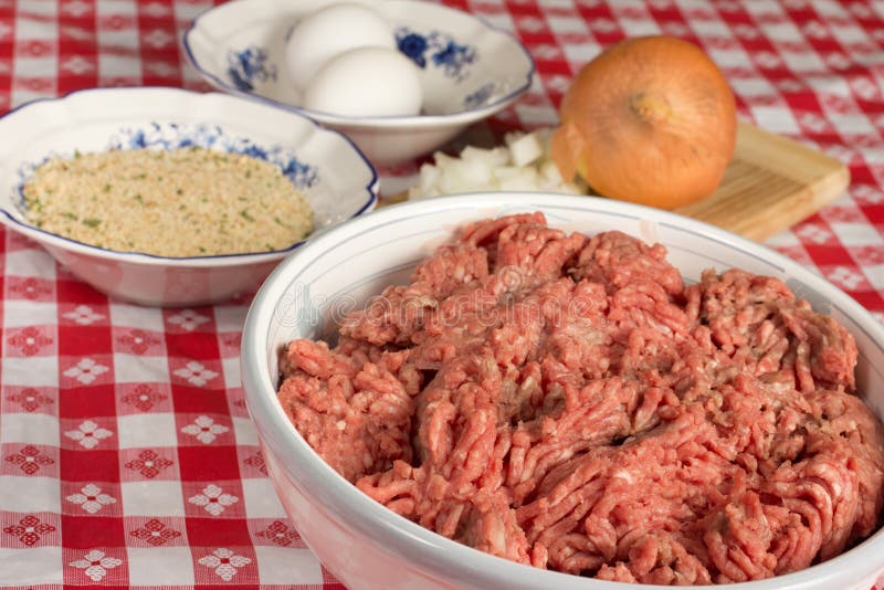 Ground beef and assorted ingredients to prepare Italian meatballs. Ground beef and assorted ingredients to prepare Italian meatballs