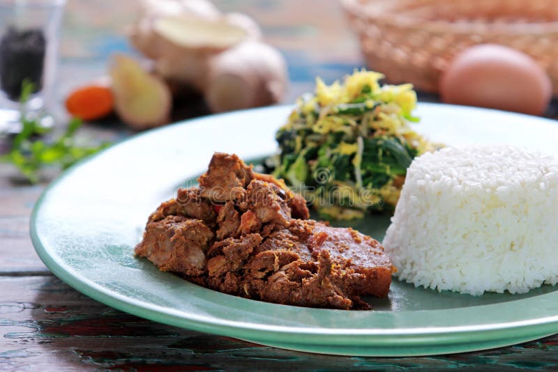 Rundvlees rendang met urap en rijst wordt gediend die stock foto Rundvlees rendang met urap en rijst wordt gediend die stock foto