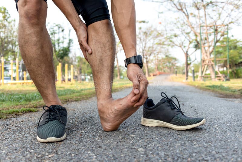 Runner have ankle twist sprain accident. Injured overtrained painful leg muscle when exercising or running and jogging outdoors royalty free stock photo Runner have ankle twist sprain accident. Injured overtrained painful leg muscle when exercising or running and jogging outdoors royalty free stock photo