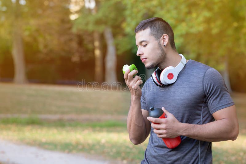 Runner latin man eating apple running jogging sports training fitness copyspace copy space