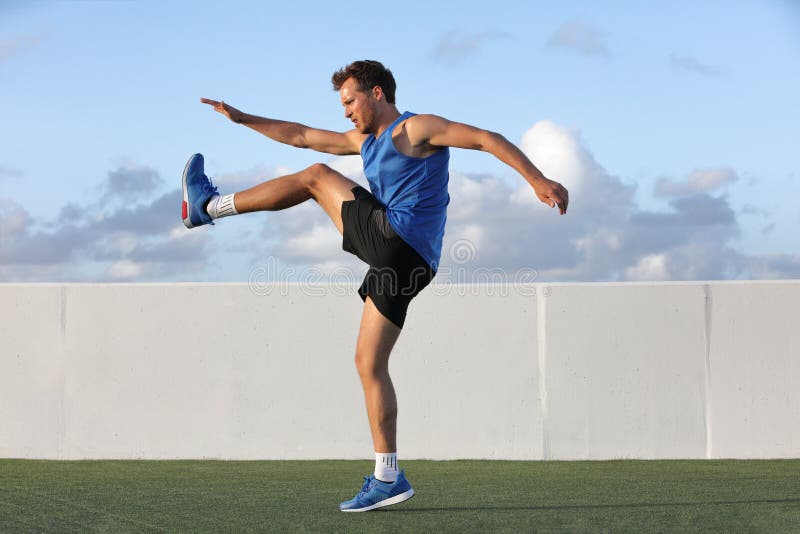 Runner man getting ready to run doing warm-up dynamic leg stretch exercises routine, Male athlete stretching lower body hamstring muscles before going running outside in summer outdoors. Runner man getting ready to run doing warm-up dynamic leg stretch exercises routine, Male athlete stretching lower body hamstring muscles before going running outside in summer outdoors