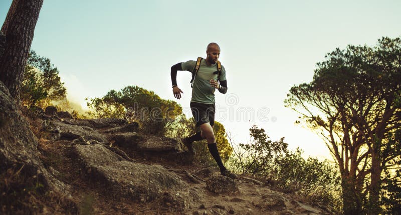 Runner running through rocky mountain path