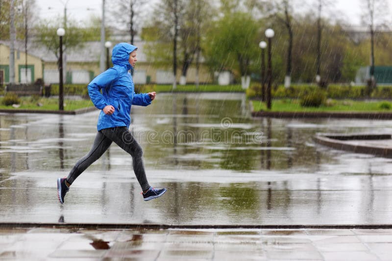 Runner woman running in Park in the rain. Jogging training for m royalty free stock photo Runner woman running in Park in the rain. Jogging training for m royalty free stock photo