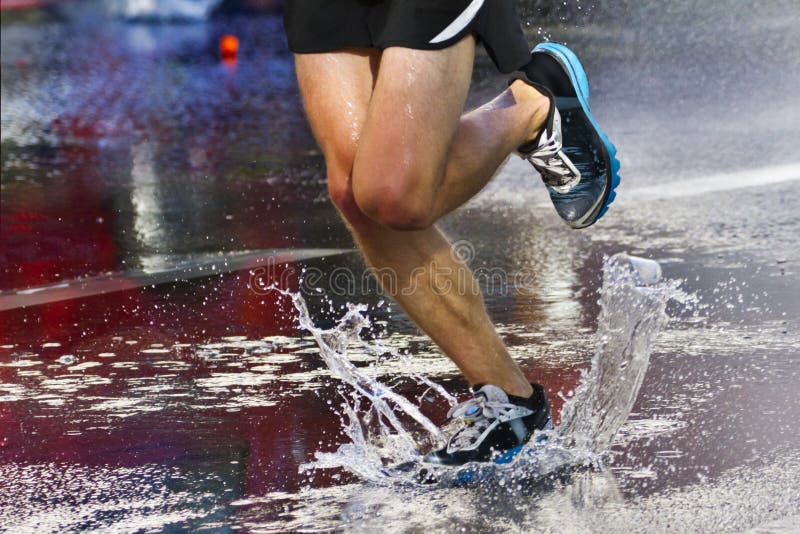 Runner runs through a puddle. Runner runs through a puddle