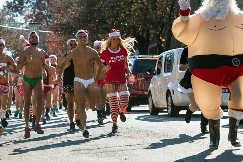 Atlanta, GA, USA - December 10, 2016: A group of runners wearing speedo swimsuits take off from the start line at the Santa Speedo Run, an annual charity fundraiser, on December 10, 2016 in Atlanta, GA. Atlanta, GA, USA - December 10, 2016: A group of runners wearing speedo swimsuits take off from the start line at the Santa Speedo Run, an annual charity fundraiser, on December 10, 2016 in Atlanta, GA.