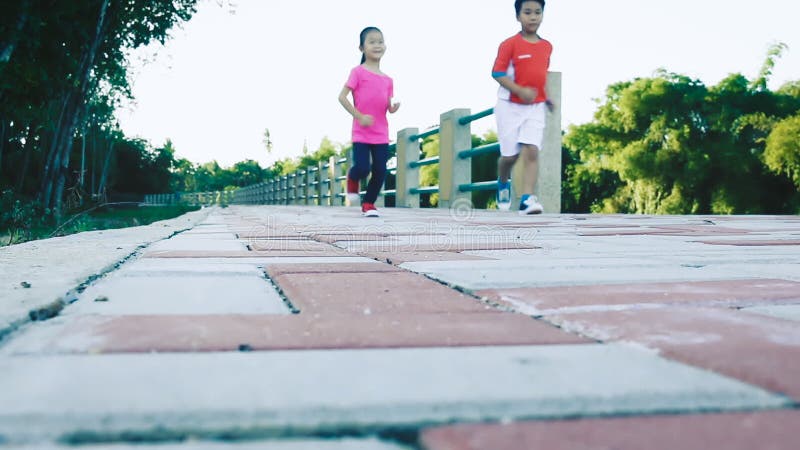 Asian children runner in sportswear jogging in public park.