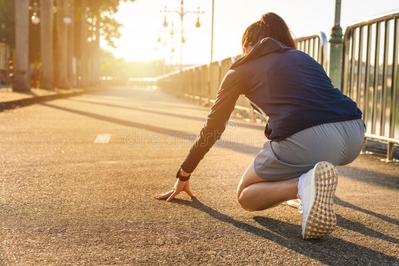 Back view of athlete runner woman in start position ready for sprint or running.