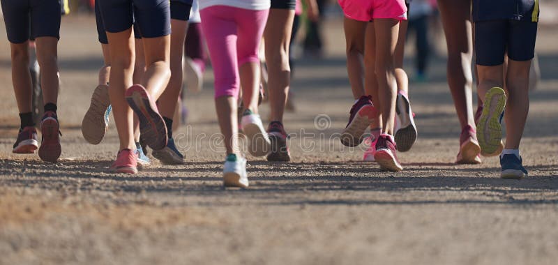 Running children, young athletes running in a kids run race, running on a park road detail on legs, running in the light of morning