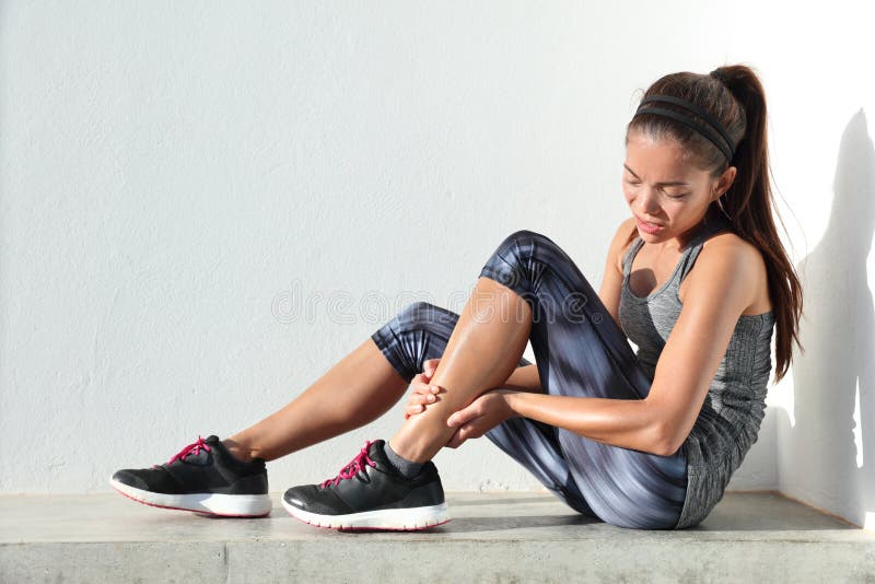 Running injury leg pain - sport woman runner holding painful sprained ankle royalty free stock images Running injury leg pain - sport woman runner holding painful sprained ankle royalty free stock images