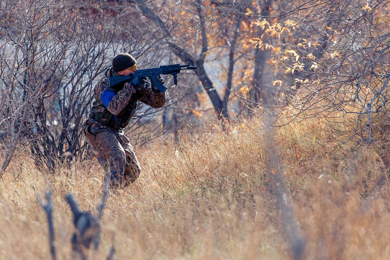 Crouching man with a gun editorial photo. Image of fighting 45584551