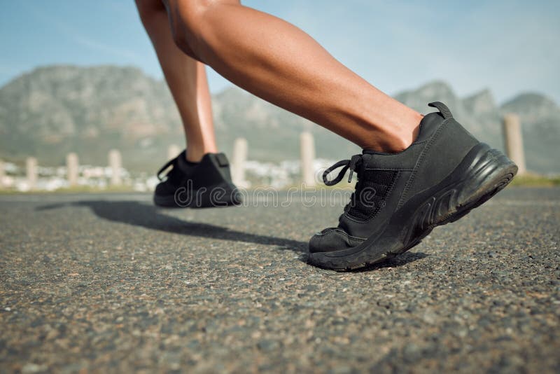 Running, person and feet or fitness on road for wellness, health and exercise by mountain. Athlete, cardio and training royalty free stock image