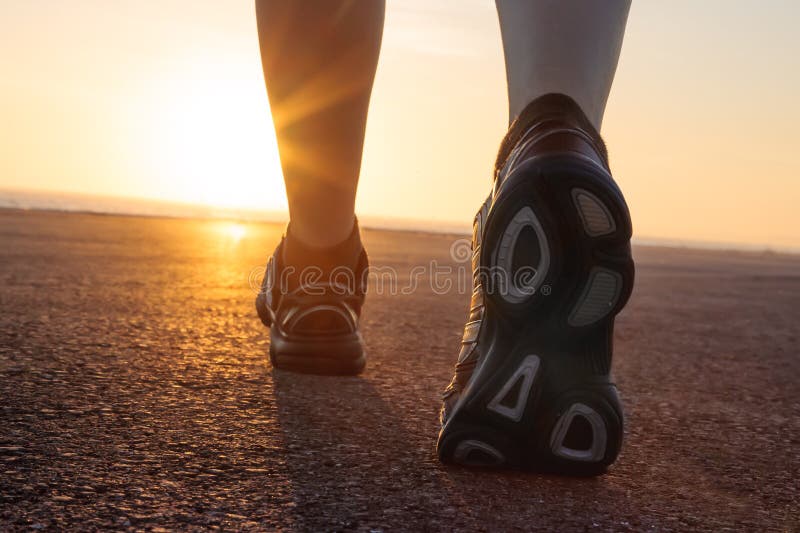 Scarpe da corsa in pista con il tramonto alle spalle.