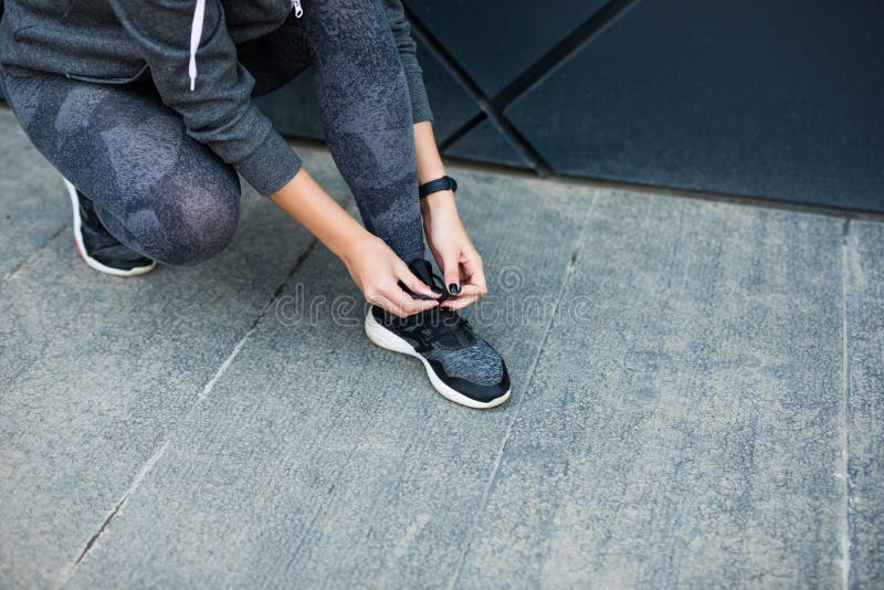 Running shoes - woman tying shoe laces. Closeup of female sport fitness runner getting ready for jogging outdoors in the city royalty free stock photo Running shoes - woman tying shoe laces. Closeup of female sport fitness runner getting ready for jogging outdoors in the city royalty free stock photo
