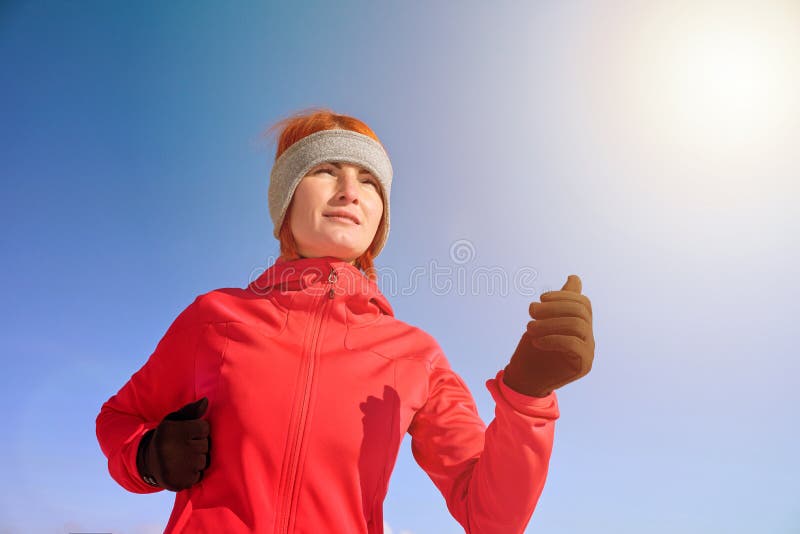 Running sport woman. Female runner jogging in cold winter park wearing warm sporty running clothing and gloves stock photos Running sport woman. Female runner jogging in cold winter park wearing warm sporty running clothing and gloves stock photos