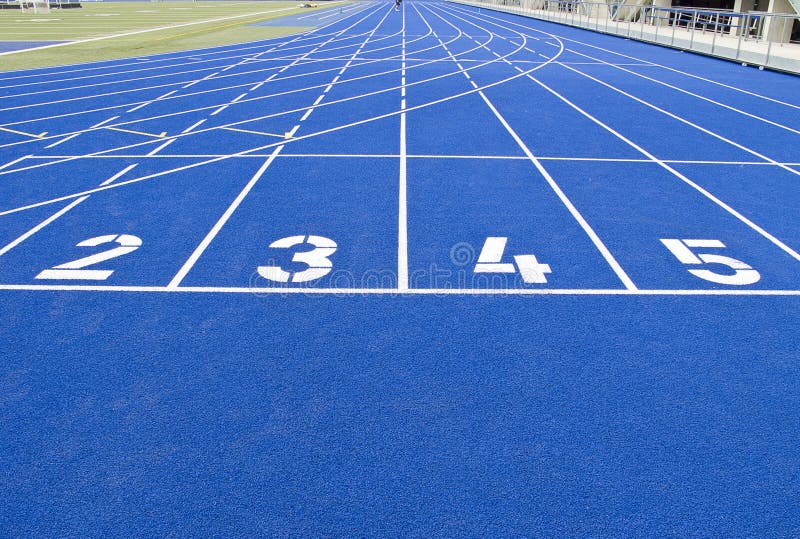 Running track in outdoor stadium with blue asphalt and white markings