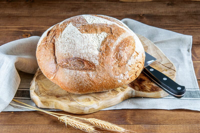 Runt, integrerat bröd och kniv på kökets trästyckningsdel. hälsosamt kott, integrerat bröd arkivbilder