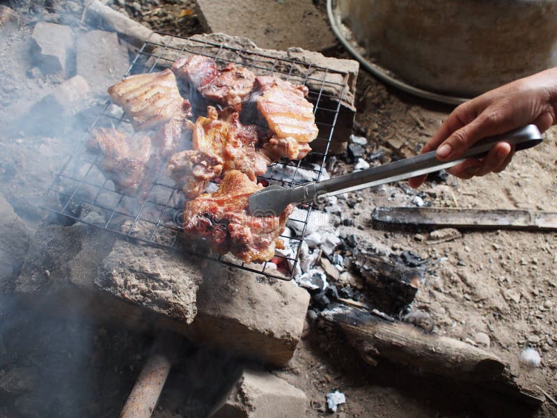 Rural chef in vintage homestay cooking fresh delicious grilled meats ribs and pork on charcoal gril. L with salt and traditional source at rural minimal kitchen royalty free stock photos Rural chef in vintage homestay cooking fresh delicious grilled meats ribs and pork on charcoal gril. L with salt and traditional source at rural minimal kitchen royalty free stock photos
