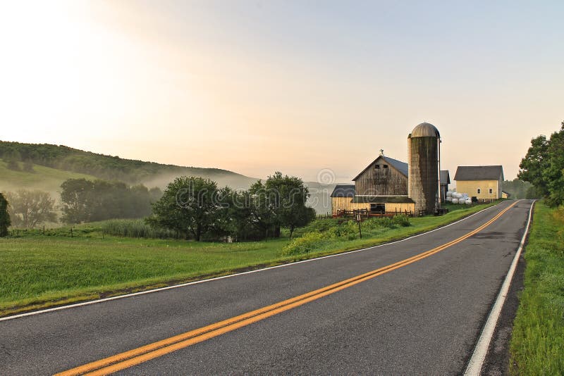 Landscape and roadscape of a rural New York farm in the early morning mist