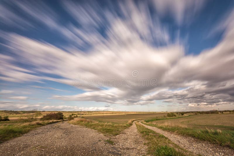 Rural region with two dirt roads and fast passing clouds royalty free stock photography Rural region with two dirt roads and fast passing clouds royalty free stock photography