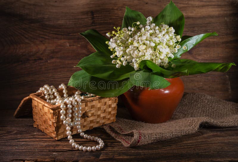 Rural still life with lilies of the valley and jewelry box on wooden background