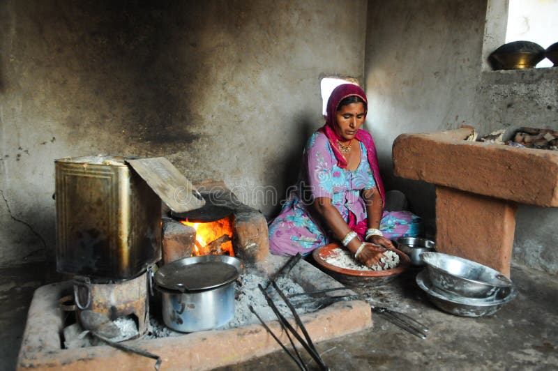 Rural Woman Cooking Chapati i hennes hus royaltyfria foton