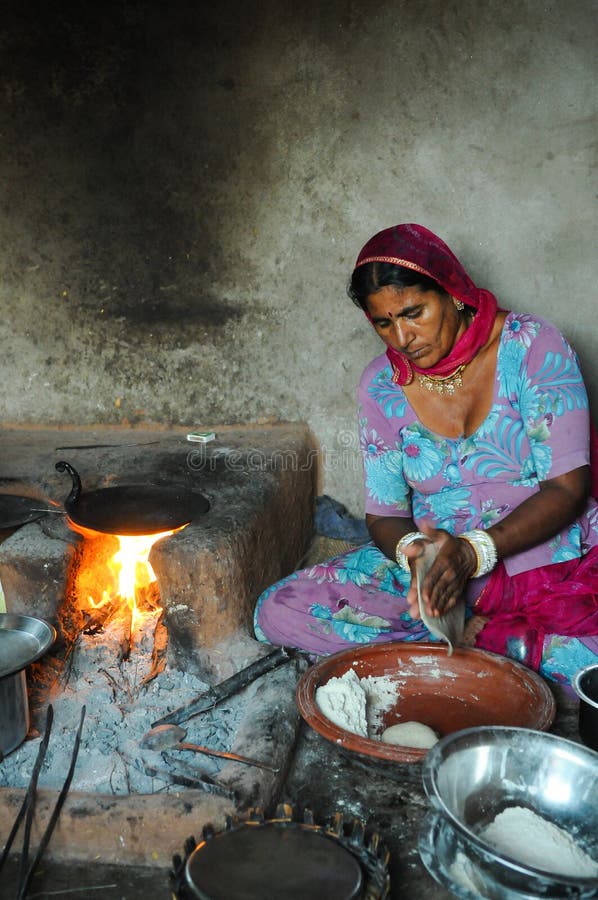 Rural Woman Cooking Chapati i hennes hus arkivbilder