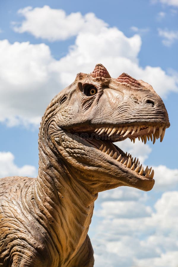 Head of a dinosaur isolated against a blue sky. Head of a dinosaur isolated against a blue sky.