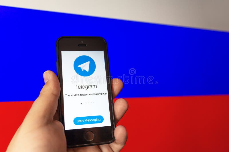 Russia, Moscow - 16 April 2018 : Telegram messenger application on smartphone in man hand at Russian flag background