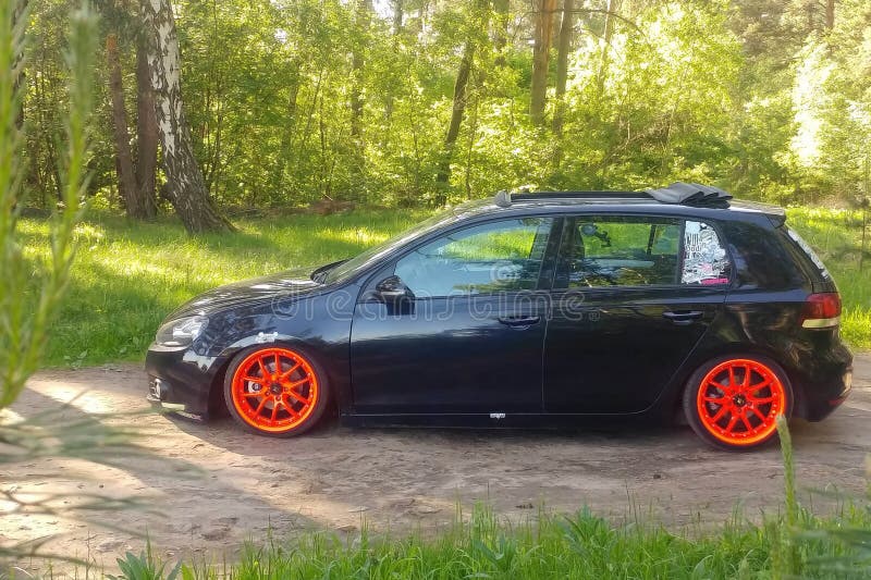 Россия, Москва-01 июня 2019 года: черный Volkswagen Golf Mk6 тюнинг с ragtop и оранжевыми колесами. Настройка стойки на пневмоподвеске В. Зеленый лес. Левая сторона Сток фотография без роялти Россия, Москва-01 июня 2019 года: черный Volkswagen Golf Mk6 тюнинг с ragtop и оранжевыми колесами. Настройка стойки на пневмоподвеске В. Зеленый лес. Левая сторона Сток фотография без роялти