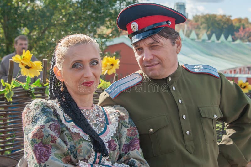 Moscow, Russia - October 1, 2016: Cossacks at a fair and Cossack gathering. Cossack and Cossack woman in love in traditional clothes, Cossack winking. Editorial. Moscow, Russia - October 1, 2016: Cossacks at a fair and Cossack gathering. Cossack and Cossack woman in love in traditional clothes, Cossack winking. Editorial.