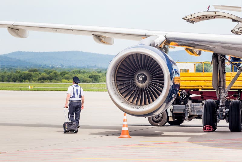 Russia vladivostok 08172020. capitano di un jet Airbus a319 vicino al motore a turbina controlla il jet prima del volo. piano fotografie stock libere da diritti