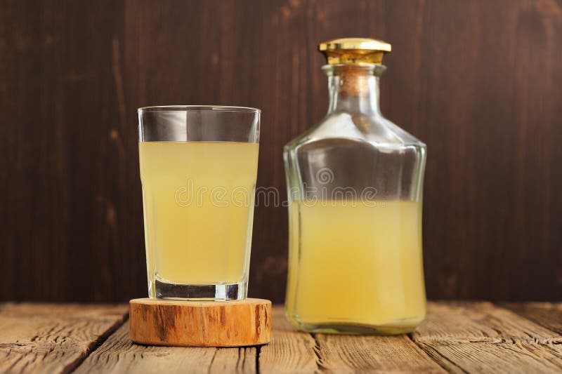 Russian cold rye beverage Kvass in glass and bottle on wooden ta