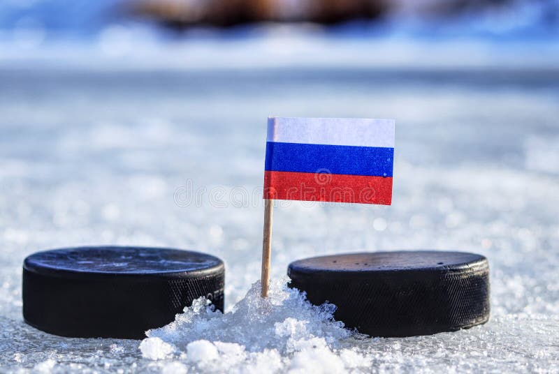 Ruská vlajka na špáradlo medzi dvoma hokejovými pukmi na vonkajšom ľade. Rusko hrá na majstrovstvách sveta v skupine B. 2019 IIHF Ice