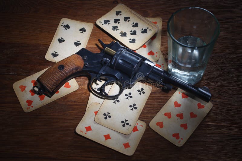 An old metal pistol with a drum on a wooden table.Russian roulette. A  revolver . Stock Photo