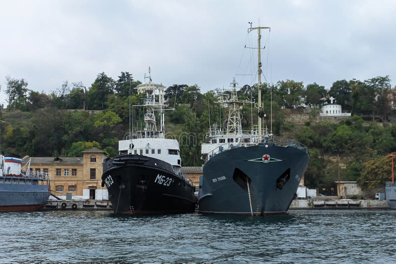 Russian ships of the Black Sea Fleet in the port of Sevastopol against the background of the gray sky. Russian ships on