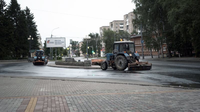 TOMSK, RUSSIA - June 2, 2020: tractors drive down the street and clean the asphalt. TOMSK, RUSSIA - June 2, 2020: tractors drive down the street and clean the asphalt.