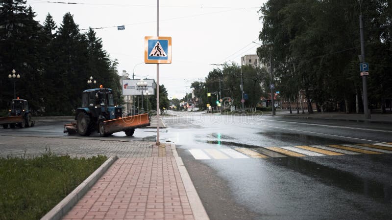 TOMSK, RUSSIA - June 2, 2020: tractors drive down the street and clean the asphalt. TOMSK, RUSSIA - June 2, 2020: tractors drive down the street and clean the asphalt.