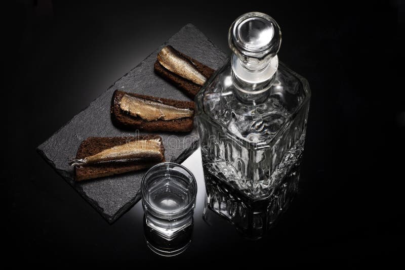 Russisch voedsel Snack met sprot en brood Karaf met alcohol en glas met wodka stock fotografie Russisch voedsel Snack met sprot en brood Karaf met alcohol en glas met wodka stock fotografie