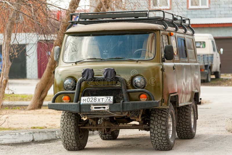 Russo brutal fora do carro UAZ da estrada na cidade foto de stock Russo brutal fora do carro UAZ da estrada na cidade foto de stock